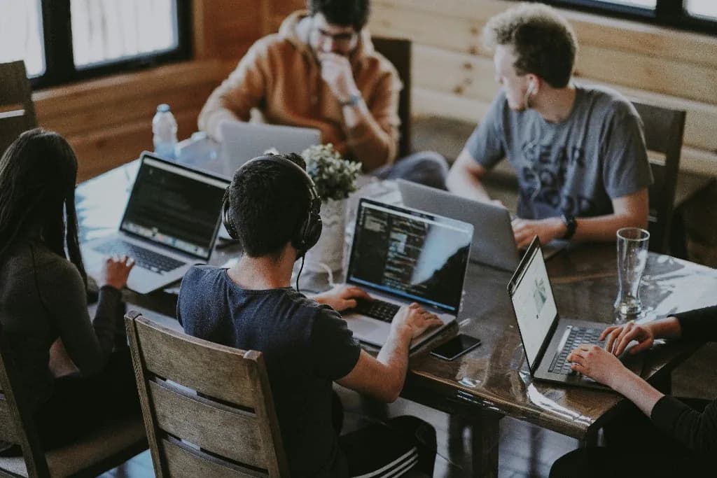 Professionnels travaillant ensemble sur des ordinateurs portables dans un espace de travail moderne